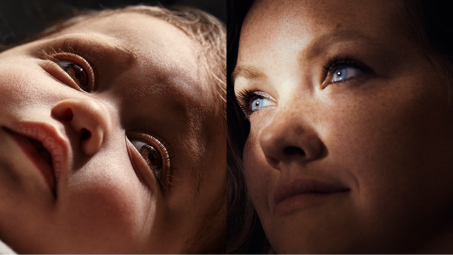 A baby's face and a woman's face shown with dramatic lighting.