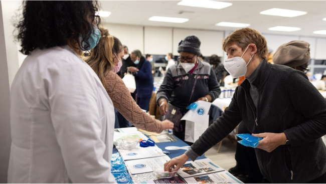 Participants get informational flyers and ask questions of specialists at a table event.