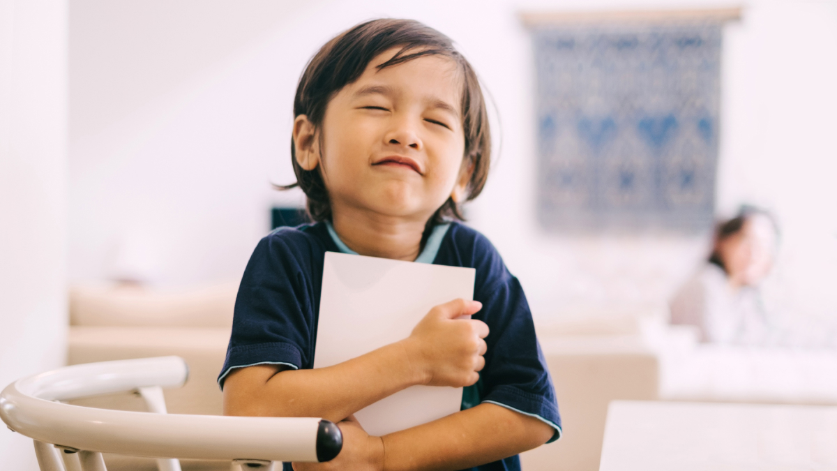 Happy child hugging a book.