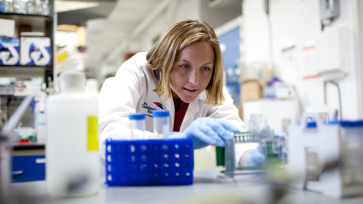 A researcher works on a lab bench running tests. 