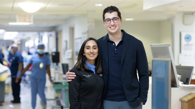 Aida Thomas and a tall man in a hospital hallway.