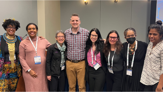 A group of conference attendees smile for the camera.