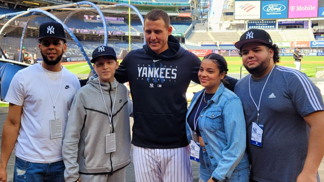 Anthony Rizzo poses with happy fans at Yankee Stadium.