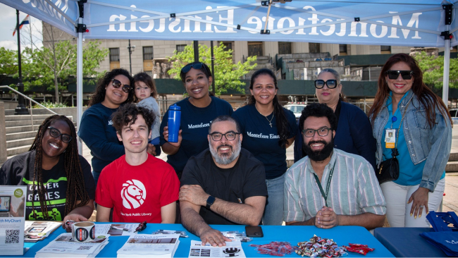 The staffers at the Montefiore Einstein tent at Bronx Week 2023 smile for a group photo.