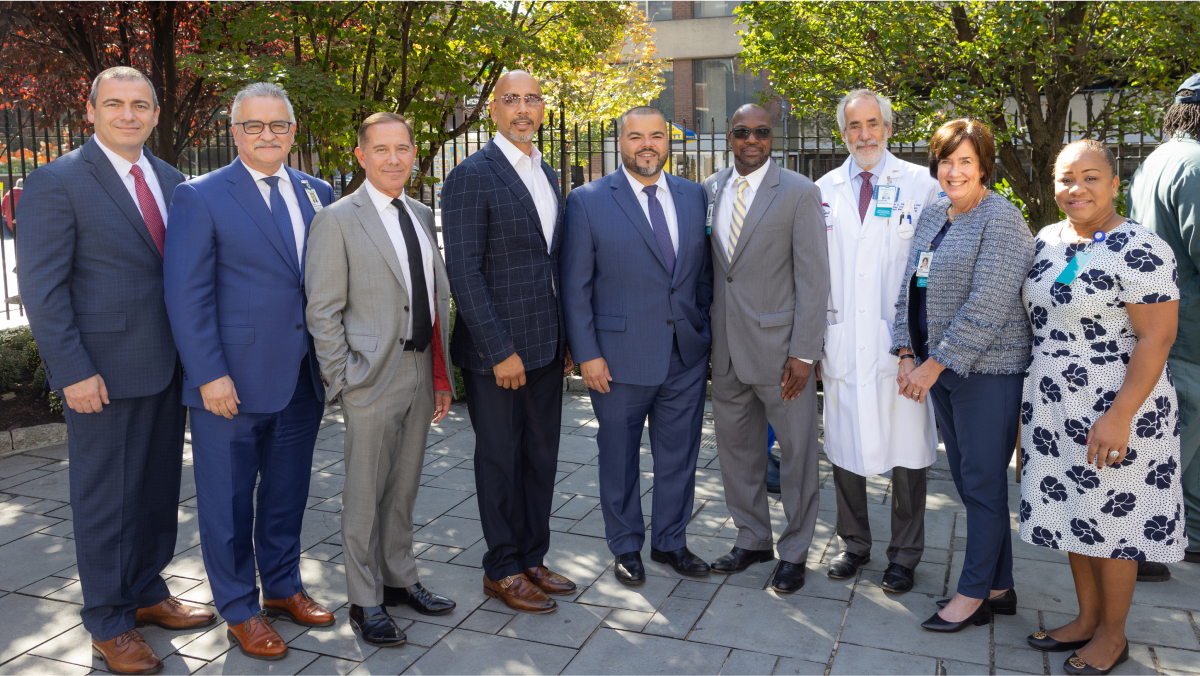 Attendees in suits and professional attire pose for a picture.