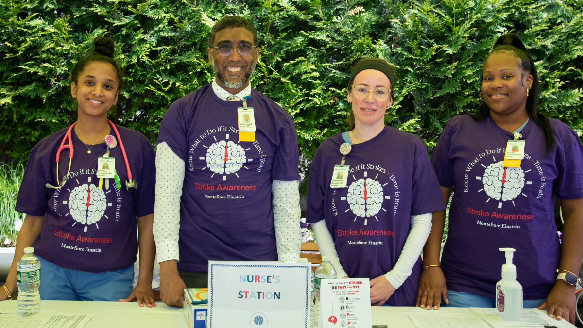 Four volunteers in matching t-shirts stand ready to help at the screening event.