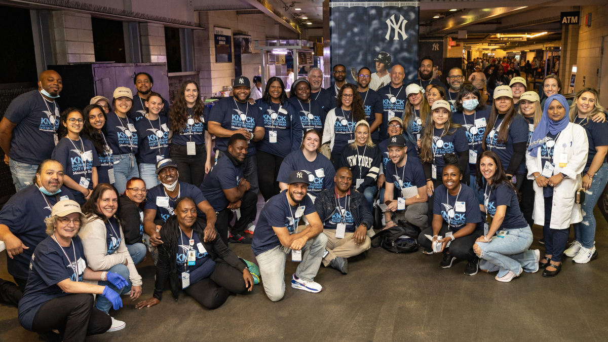 A crowd of happy staff and attendees pose for a group photo.