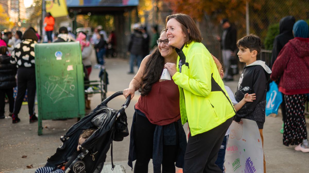 Two people hug on the sidelines of the marathon.