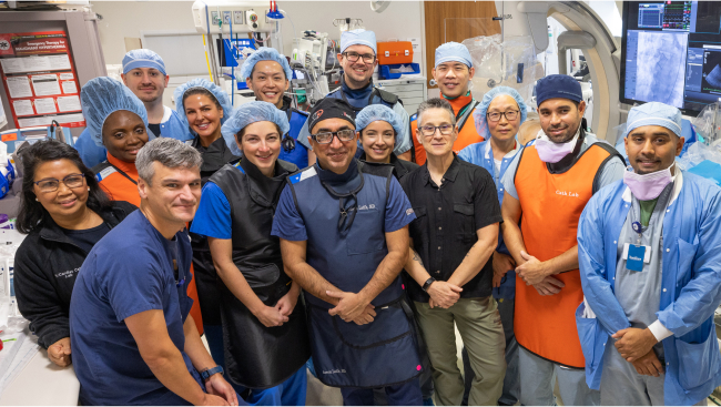 A large medical team in scrubs poses for a picture.