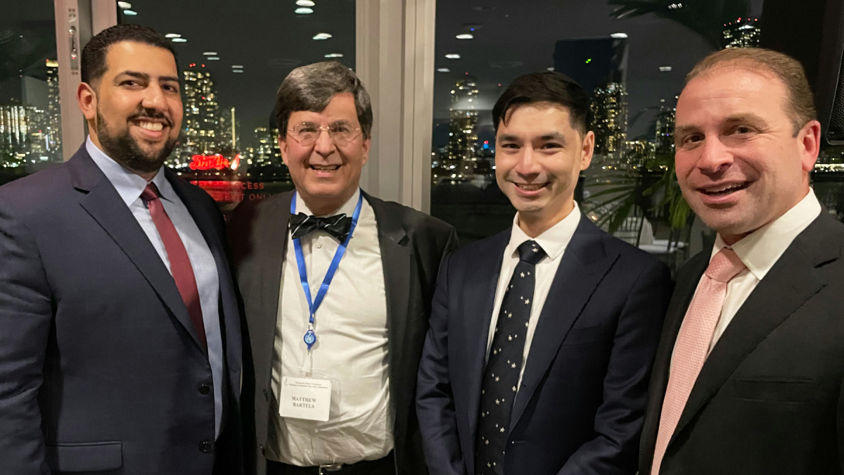 Dr. Bartels and three other attendees smile for a photo.