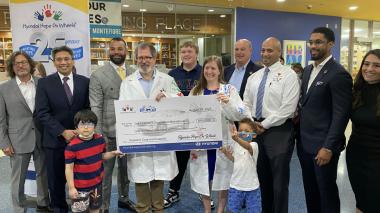 Staff and family gather as Dr. Loeb accepts a ceremonial check.