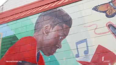 A detail from a wall mural featuring a young boy, a butterfly, a musical note and a book.